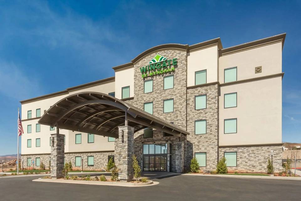 Wingate by Wyndham hotel with a stone-clad entrance canopy under a blue sky